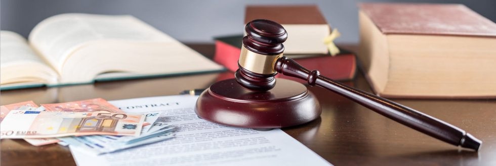 Gerichtshammer neben Bargeld und schriftlichen Abkommen