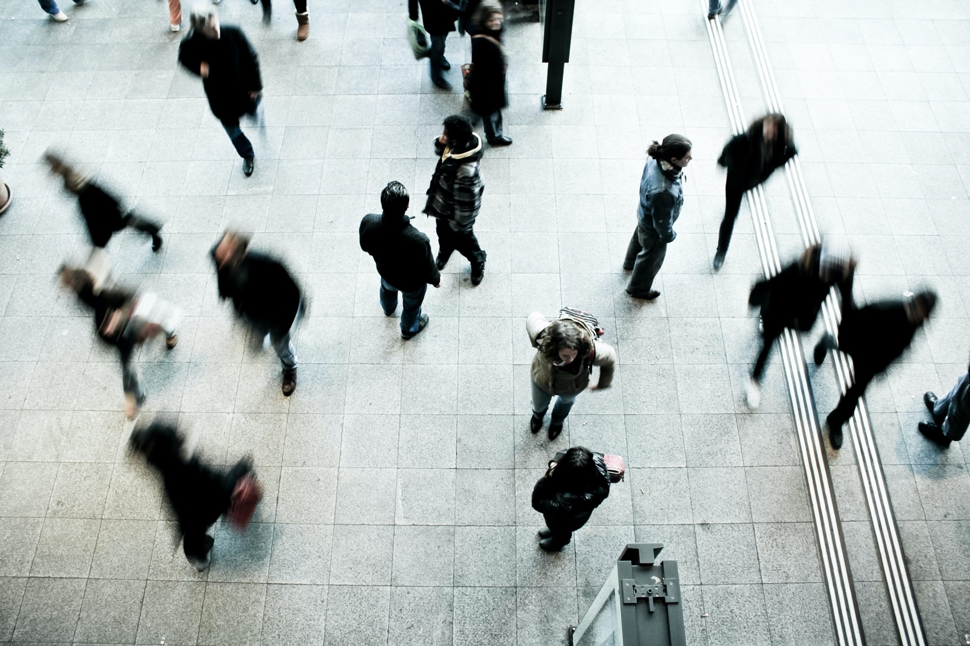 Menschen laufen am Bahnhof umher
