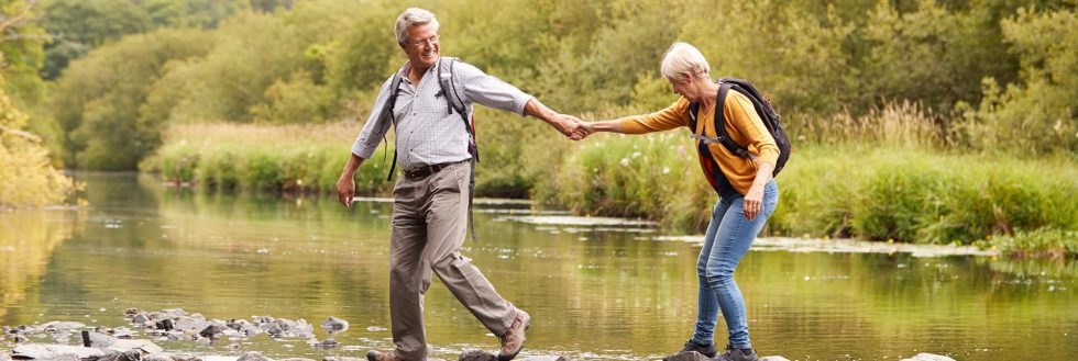 Altes Ehepaar überquert Fluss Symbol als Rückkehr als Grenzgänger nach Deutschland